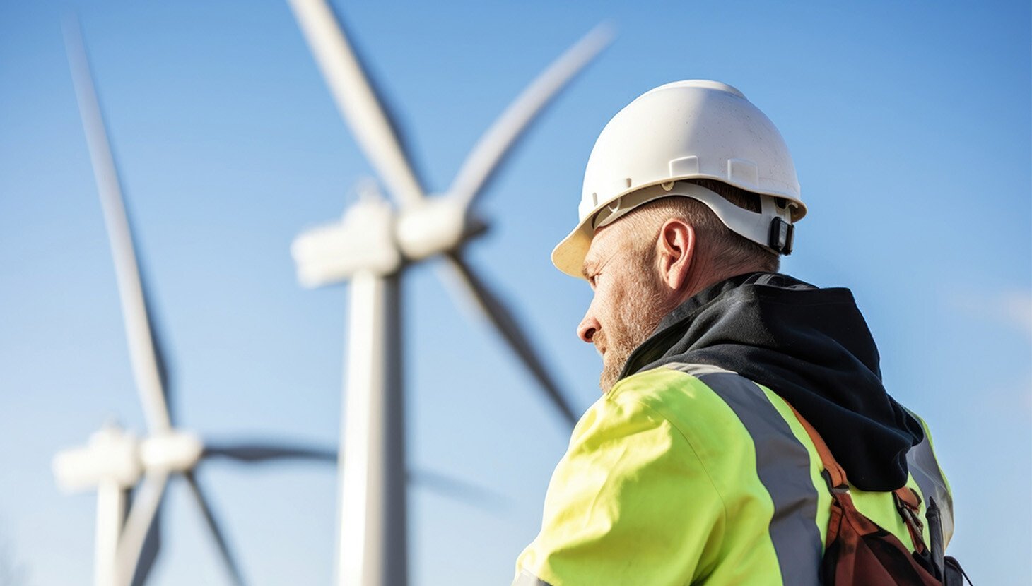 Man standing beside wind turbines