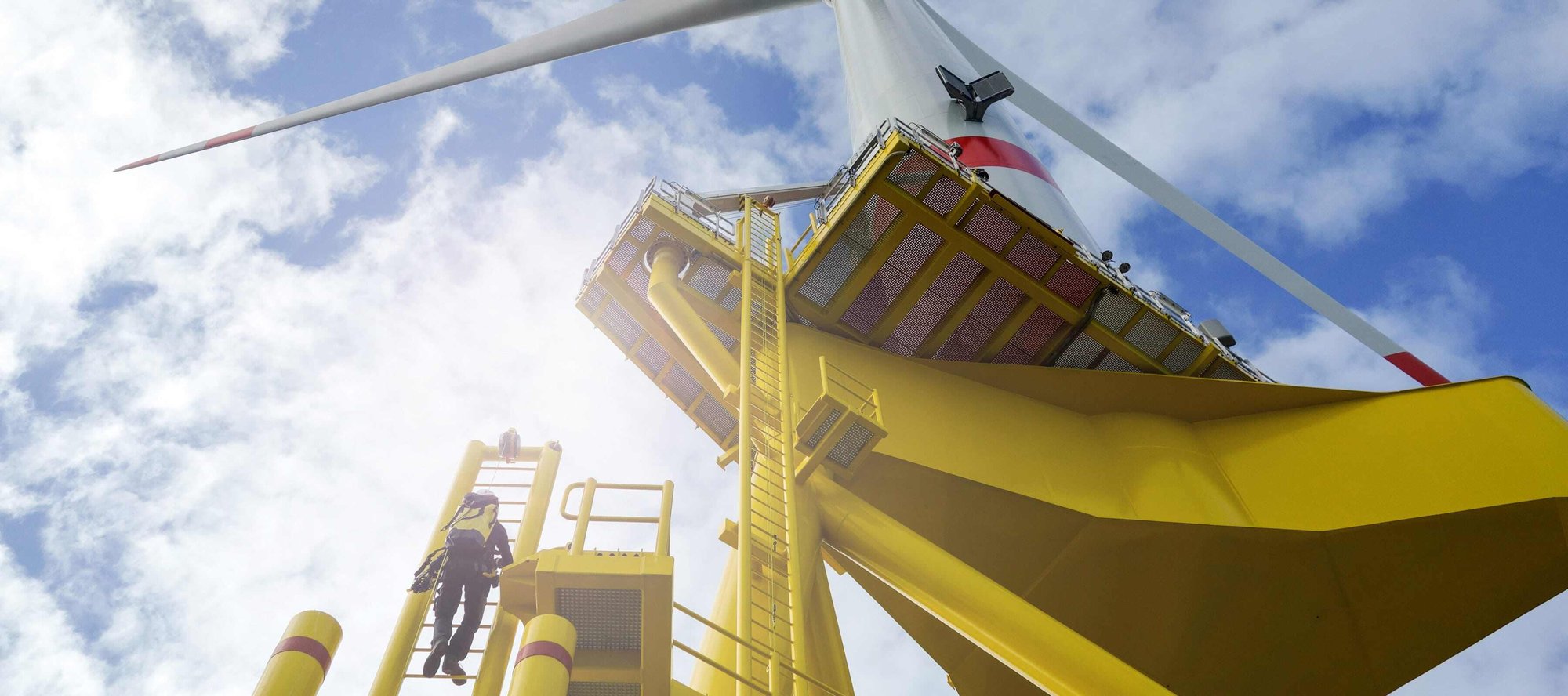 Worker climbing wind turbine