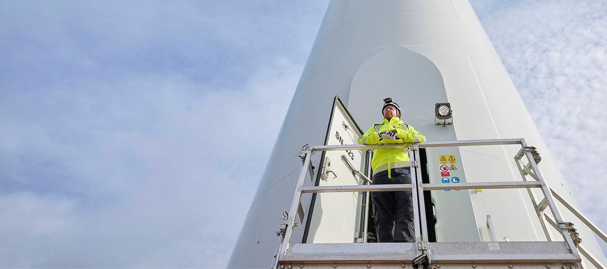 Man standing looking out from wind turbine